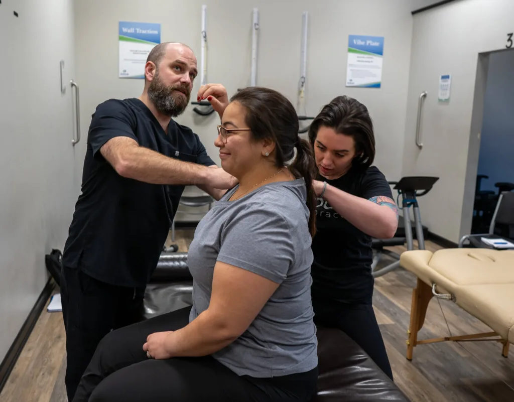 Dr. Christopher Allin and a student engage in a hands-on neuromyofascial therapy exercise, focusing on upper body adjustments.